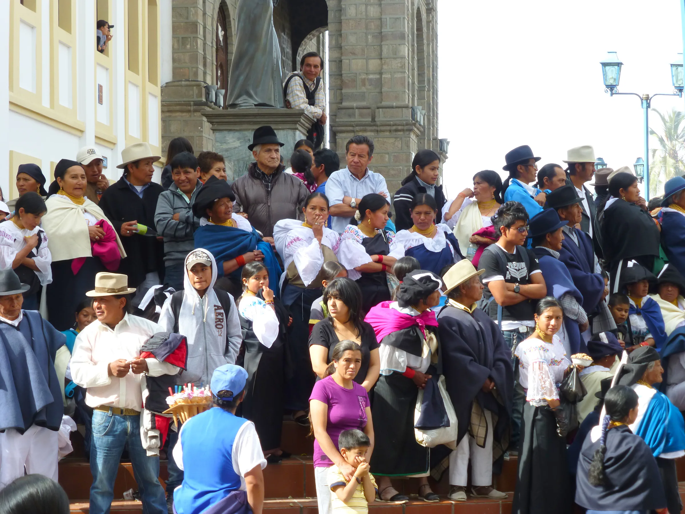 Crowd watches from the steps of the Church. Per wikitravel.org website, "Cotacachi Village is a small town of 20.000 inhabitants some 20km north of Otavalo. The town is famous for its leather goods."