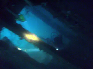 Flash light beams illuminate our way through the cargo holds.