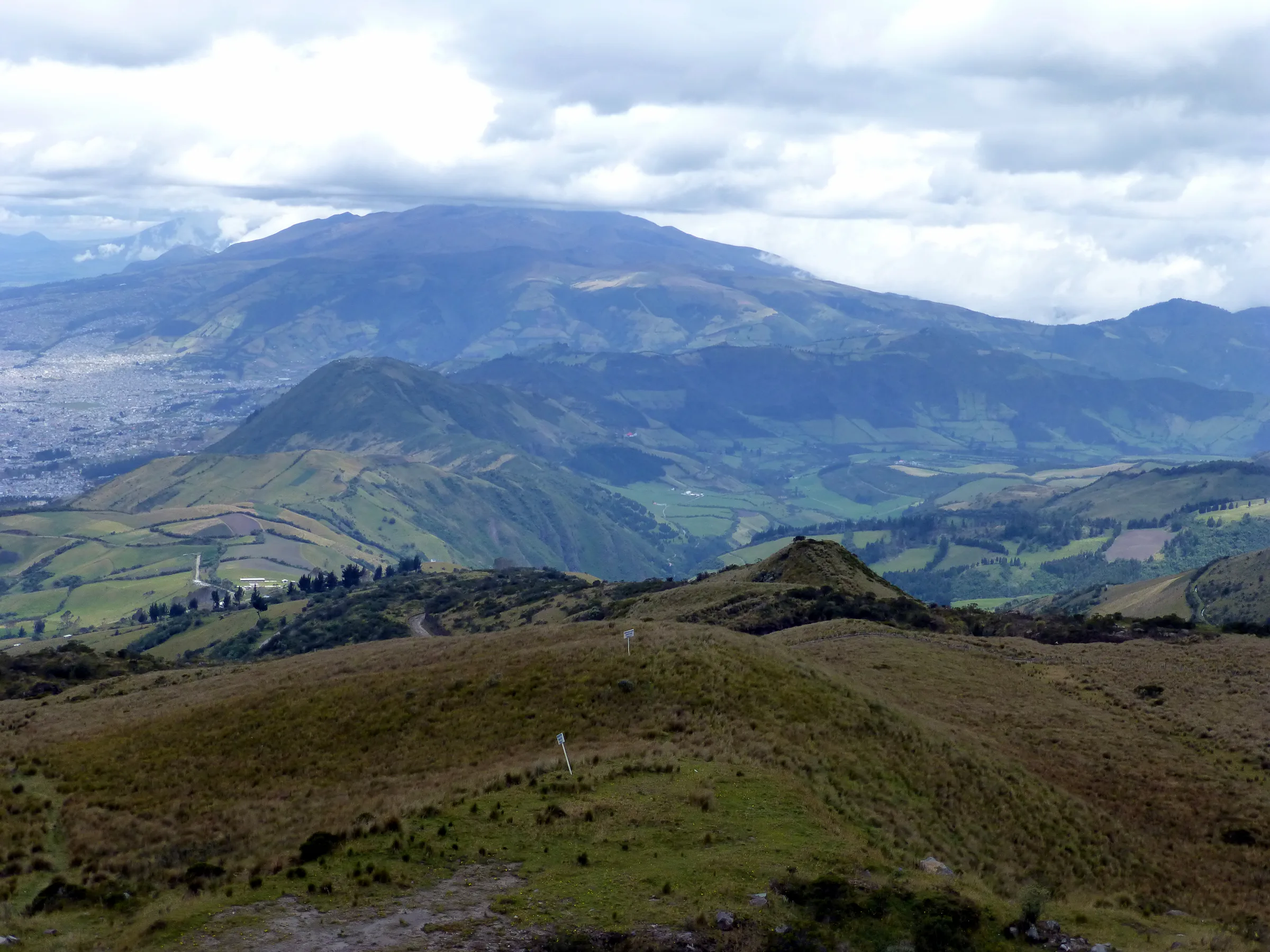 View of a volcano and farm land west of Quito. The top of the El Teleferico is 4,050 meters high, far above timberline.