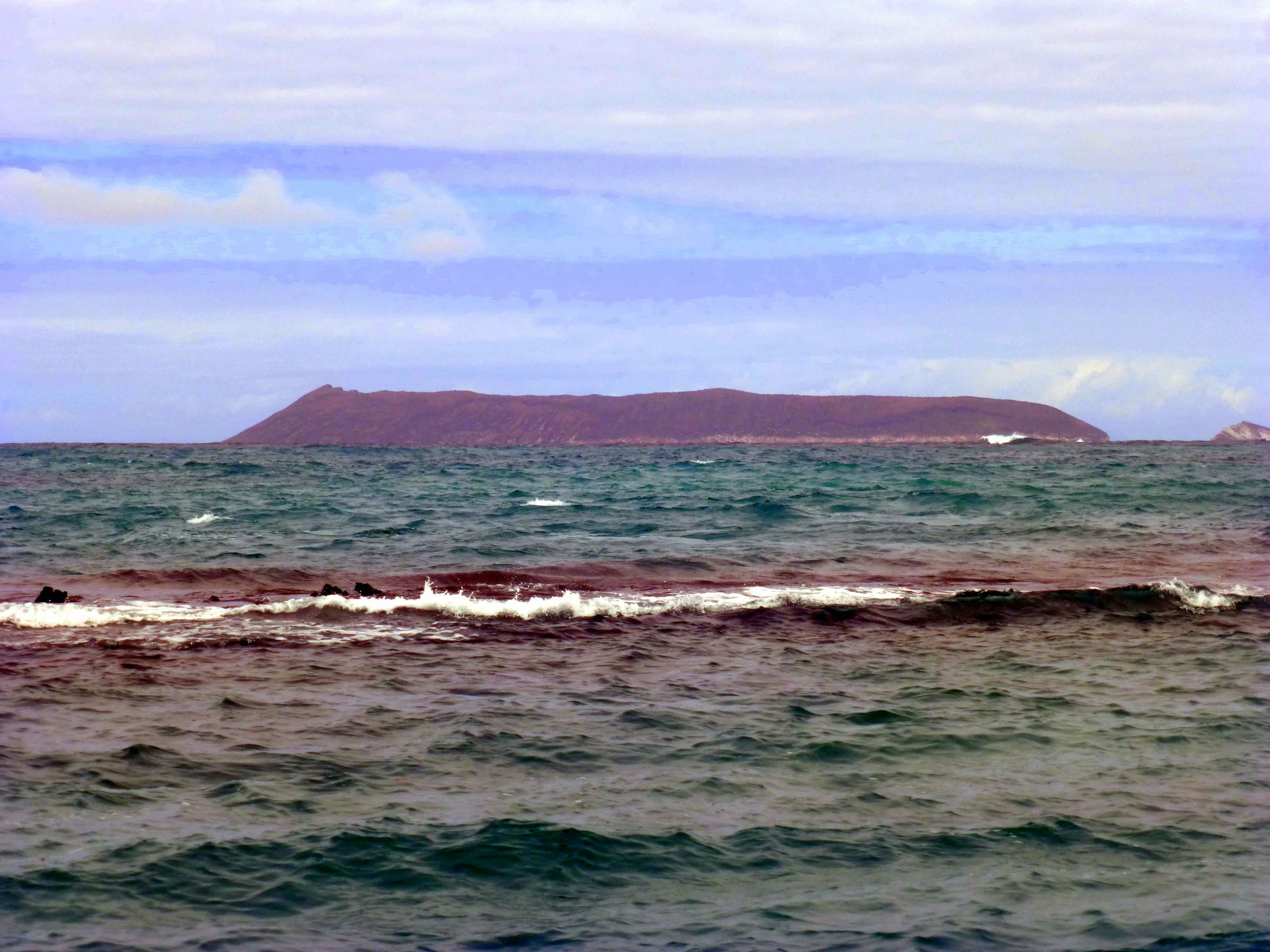 The Island of Fernandina.   "The youngest and the most active volcanoes in Galapagos are found in the island of Ferdinand", and it is unhabited (by humans). http://www.galapagosnow.com/dive-sites/ferdinand-island