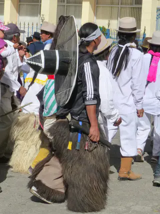 Procession. Young man with a weapon in his hand. Per wikitravel.org website, "Cotacachi Village is a small town of 20.000 inhabitants some 20km north of Otavalo. The town is famous for its leather goods."