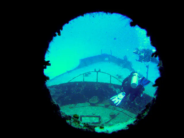 Looking out a porthole of the ship's helm at the bow and two divers.