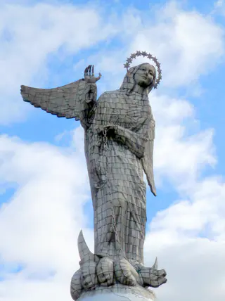 El Panecillo.  On this mountain, an angel overlooks the City of Quito. Per Wikipedia, "In 1976, the Spanish artist Agustín de la Herrán Matorras was commissioned by the religious order of the Oblates to build a 45-metre-tall aluminum monument of a madonna which was assembled on a high pedestal on the top of Panecillo. It is made of seven thousand pieces of aluminium. ...The virgin stands on top of a globe and is stepping on a snake, which is a classic madonna iconography. Less traditional are the wings. Locals claim that she is the only one in the world with wings like an angel. The monument was inspired by the famous "Virgen de Quito" (Quito's Madonna) also known as "the dancer" sculpted by Bernardo de Legarda in 1734, which now decorates the main altar at the Church of St. Francis. ...According to a bronze placard affixed to the monument, the woman represented by the statue is the Woman of the Apocalypse, as described in the Book of Revelation (Revelation 12:1–18)."
