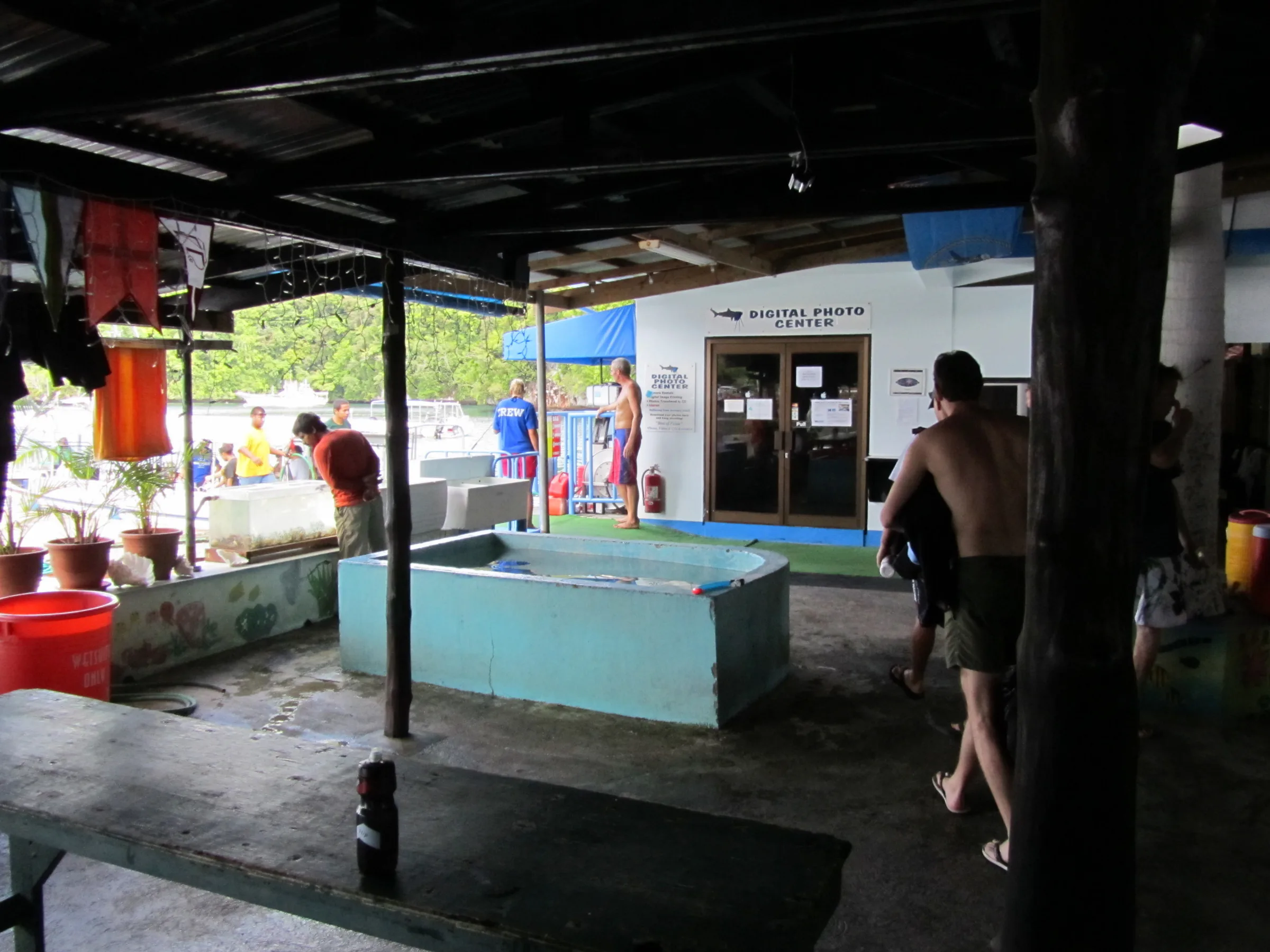 Sam's Tours rinse tank. On the left side are three red barrels for wetsuits, in the foreground is the general rinse tank, and two white tanks behind it are for rinsing dive cameras.