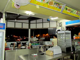 "I Love Noodles" Restaurant. The kitchen and menu display overhead, On the menu are our favorites such as fruit ice, "milke tea", "fried squid balls," and "meat pie."