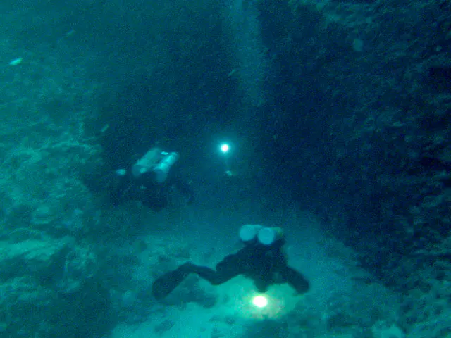 Expert Cave divers (two tanks on backs) enter the "Temple of Doom" at 90' at the bottom of the Blue Holes. The Temple of Doom derives its name from divers and turtles that have perished in the cave's labyrinth.
