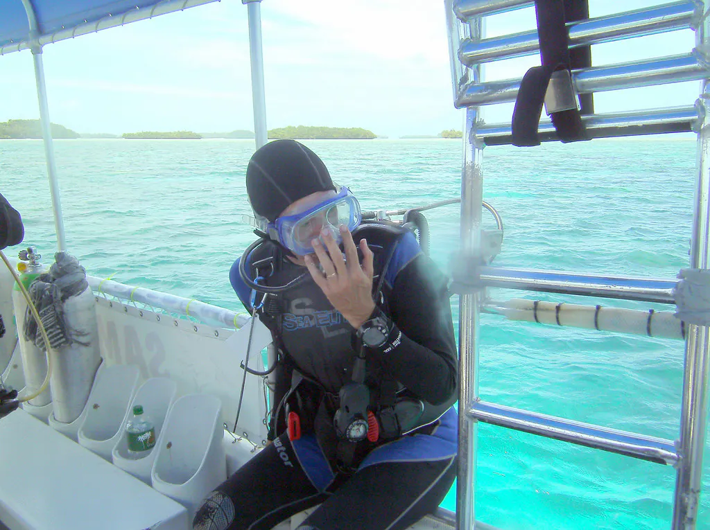 I am preparing to begin a dive by a back entry off of the boat.  To do so, I place my hand in front of my face to hold my mask and regulator, as I roll from the boat backwards into the water, tank first.