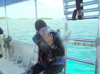 I am preparing to begin a dive by a back entry off of the boat.  To do so, I place my hand in front of my face to hold my mask and regulator, as I roll from the boat backwards into the water, tank first.