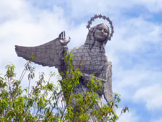 El Panecillo.  On this mountain, an angel overlooks the City of Quito. Per Wikipedia, "In 1976, the Spanish artist Agustín de la Herrán Matorras was commissioned by the religious order of the Oblates to build a 45-metre-tall aluminum monument of a madonna which was assembled on a high pedestal on the top of Panecillo. It is made of seven thousand pieces of aluminium. ...The virgin stands on top of a globe and is stepping on a snake, which is a classic madonna iconography. Less traditional are the wings. Locals claim that she is the only one in the world with wings like an angel. The monument was inspired by the famous "Virgen de Quito" (Quito's Madonna) also known as "the dancer" sculpted by Bernardo de Legarda in 1734, which now decorates the main altar at the Church of St. Francis. ...According to a bronze placard affixed to the monument, the woman represented by the statue is the Woman of the Apocalypse, as described in the Book of Revelation (Revelation 12:1–18)."