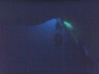 Moving from darkness toward the distant underwater exit of the Virgin Blue Hole, Palau.
