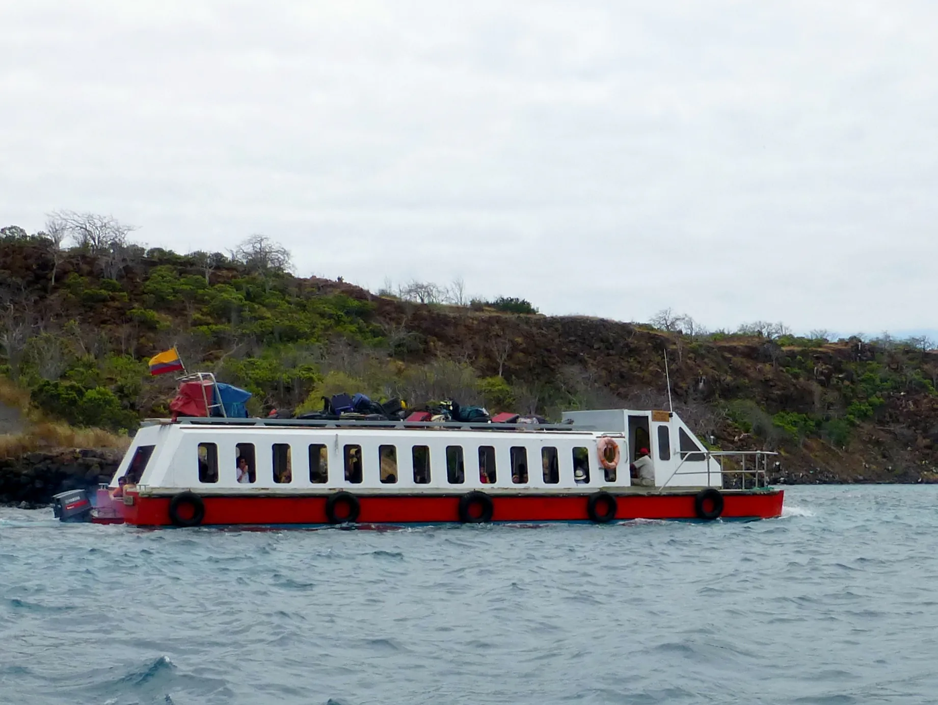 Ferry from Baltra to Santa Cruz. Luggage goes on top, passengers below. The ferry is slow! Powered by only two small outboard motors.
