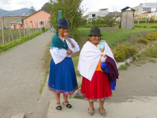 Otavalo women waiting at a bus stop.