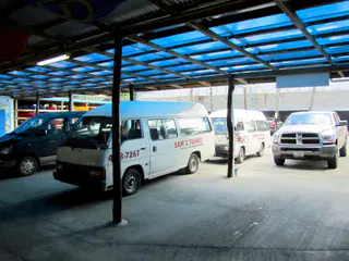 Sam's Tours minivans parked at the arrival area at Sam's Tours.