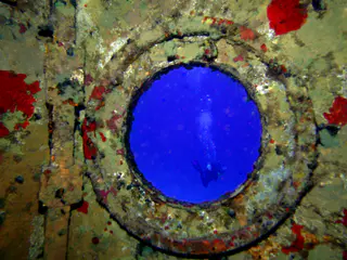 Porthole with diver in the distance.